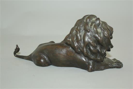 A patinated bronze model of a recumbent lion, 9in.